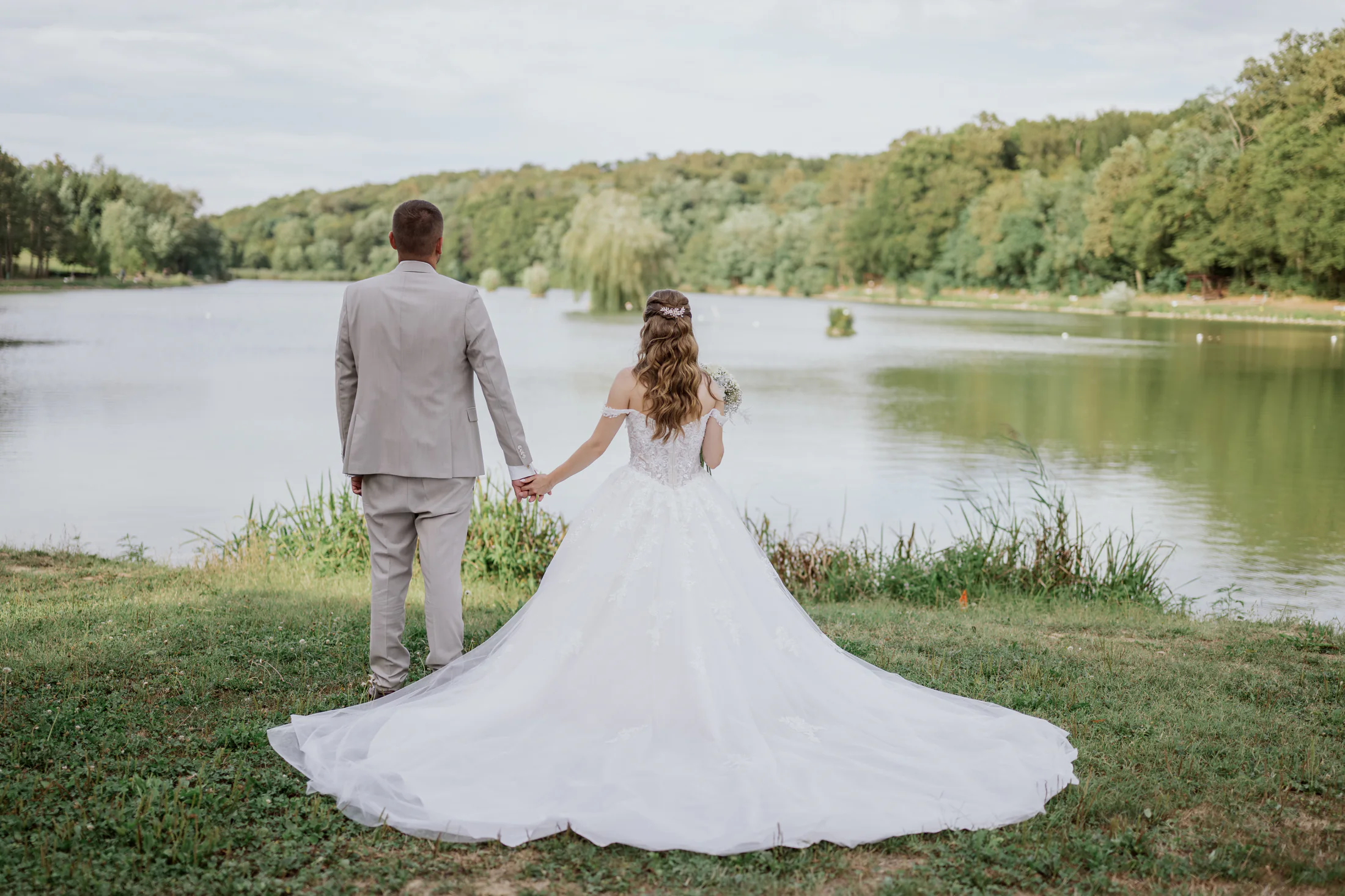 Bride and groom beside a quiet lake